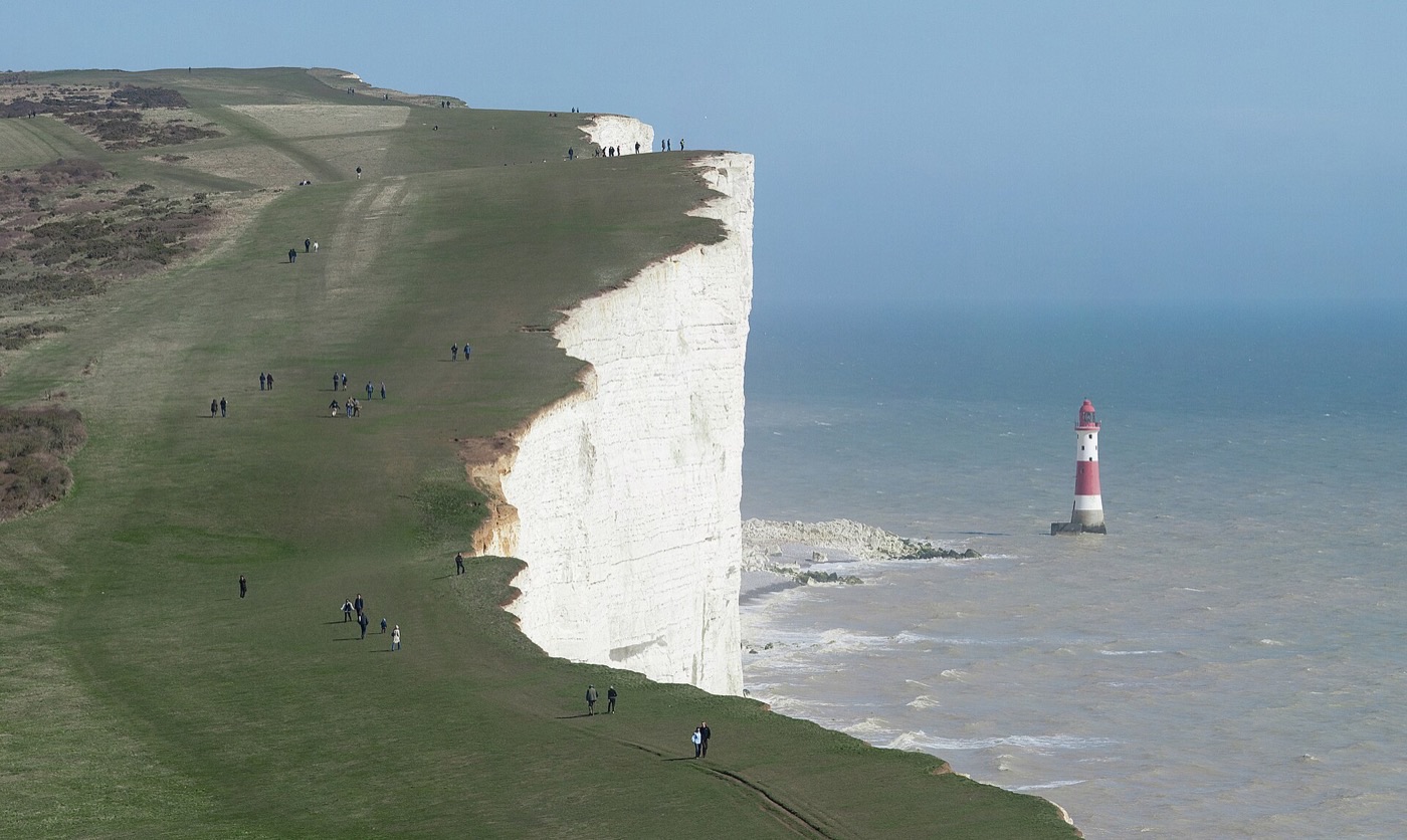 Beachy Head white chalk cliff and the red-and-white lighthouse below